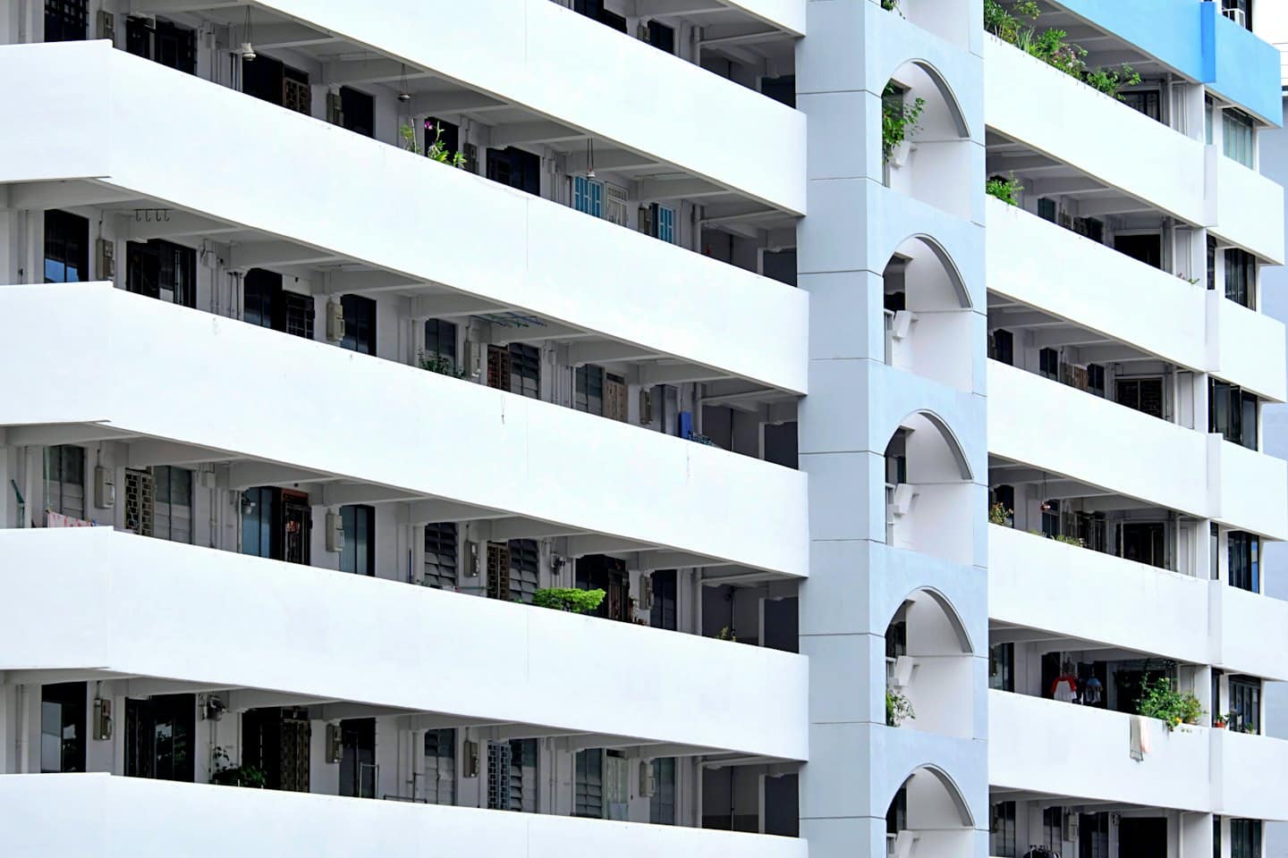 Modern appartementengebouw met witte balkons en boogvormige ontwerpelementen.