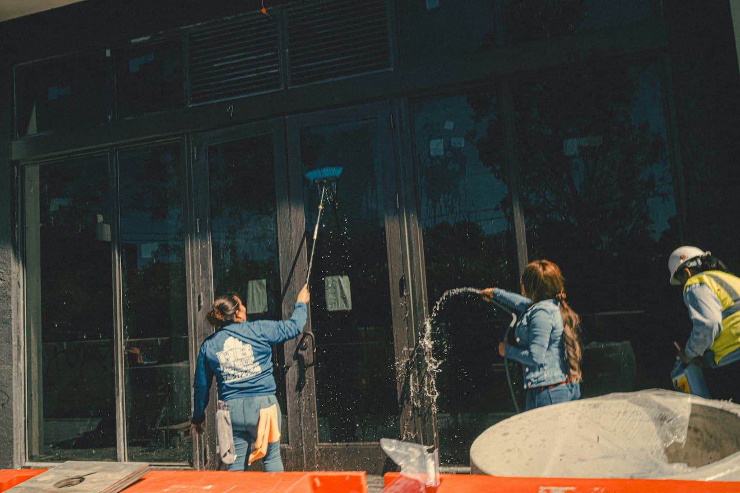 Werknemers maken de grote glazen ramen van een modern gebouw schoon.